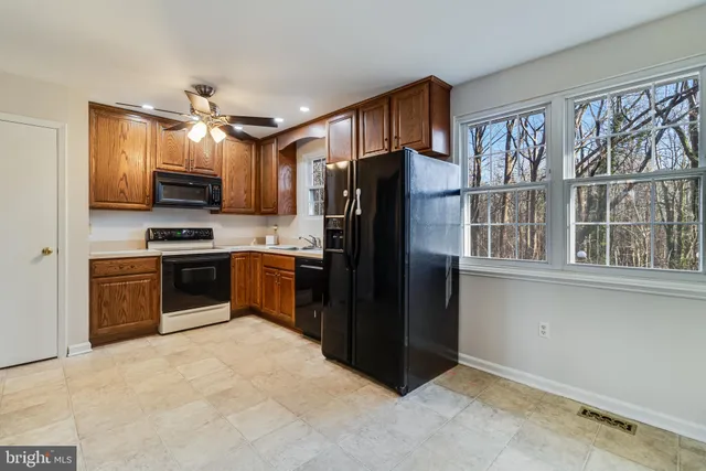 a kitchen with granite countertop a refrigerator and a stove top oven