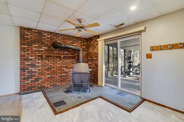 a view of a hallway with wooden floor and a ceiling fan