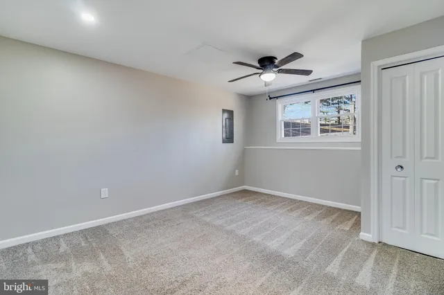 a view of an empty room with a ceiling fan and a window