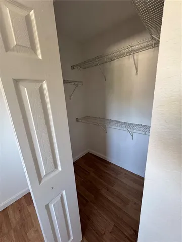 a view of walk in closet with wooden floor