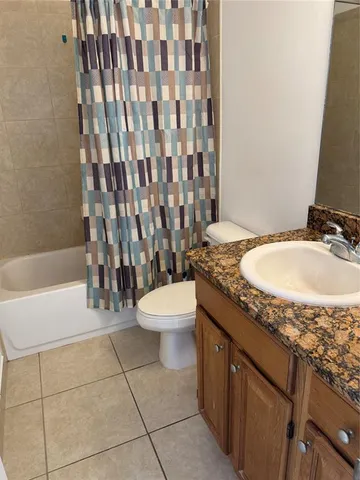 a bathroom with a granite countertop sink toilet a mirror and bathtub