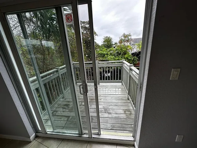 a view of a balcony with wooden floor and door