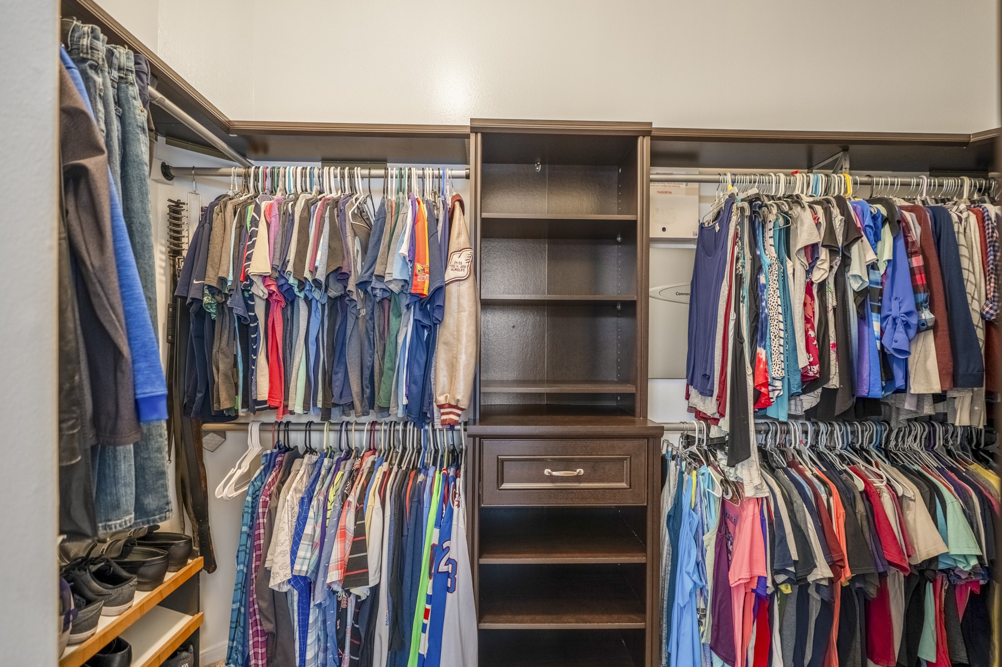 3411 Utah Beach Court Spring, TX 77388 - Photo 23 of 50 Inside the remodeled primary walk-in closet, built-in shelving wraps the space with double hanging areas, open shelves, drawers, and dedicated shoe storage. Positioned just off the primary bath, it keeps the suite organized and easy to move through from bedroom to bath to closet.