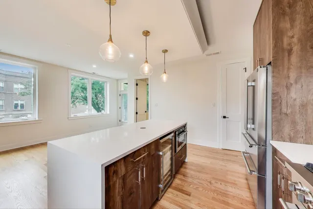 a kitchen with stainless steel appliances a sink and a wooden floor