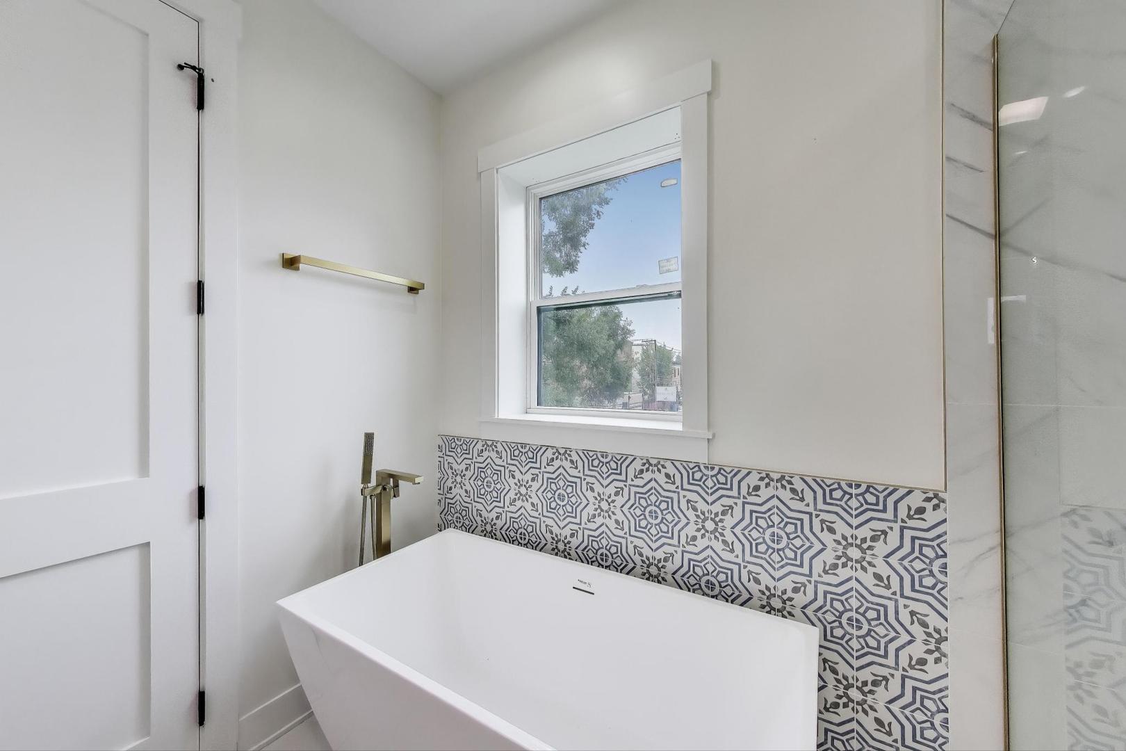 6363 South Ellis Avenue, Unit 2 Chicago, IL 60637 - Photo 9 of 18 a white bath tub sitting next to a window