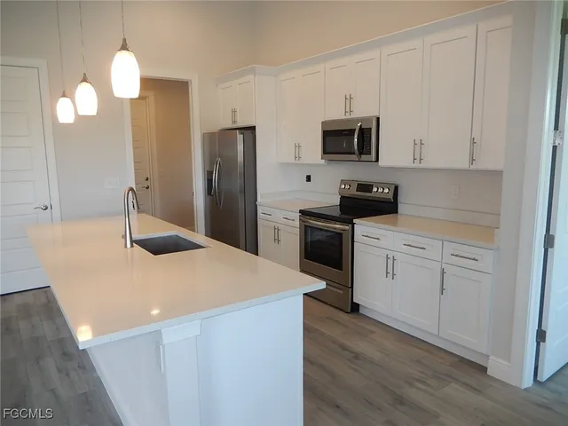 a kitchen with stainless steel appliances a stove refrigerator sink and microwave