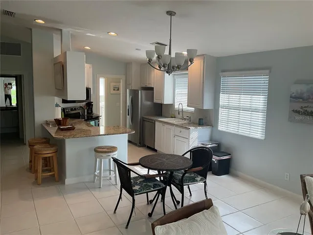 a kitchen with stainless steel appliances granite countertop a stove a refrigerator and a microwave