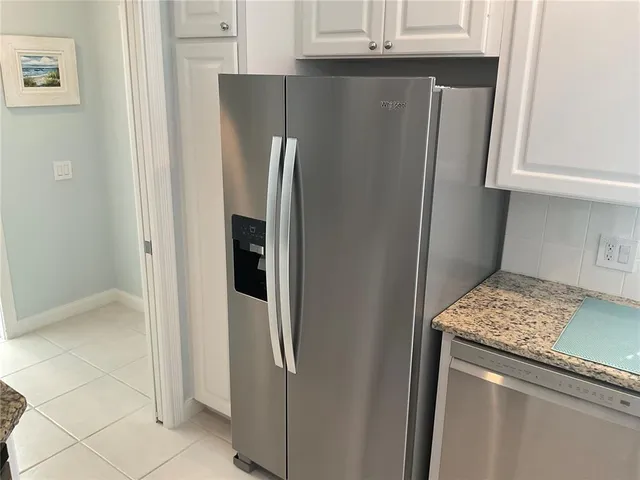a kitchen with a granite countertop sink and refrigerator
