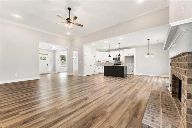 a view of a livingroom with wooden floor and a ceiling fan