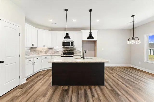 a kitchen with kitchen island sink stove and cabinets