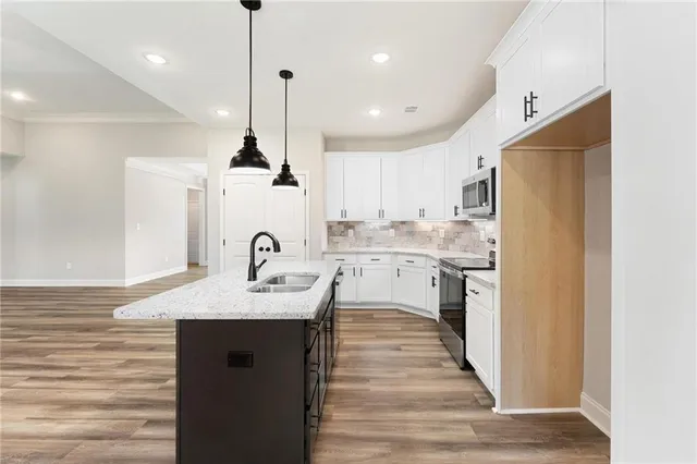 a kitchen with kitchen island a sink stainless steel appliances and cabinets
