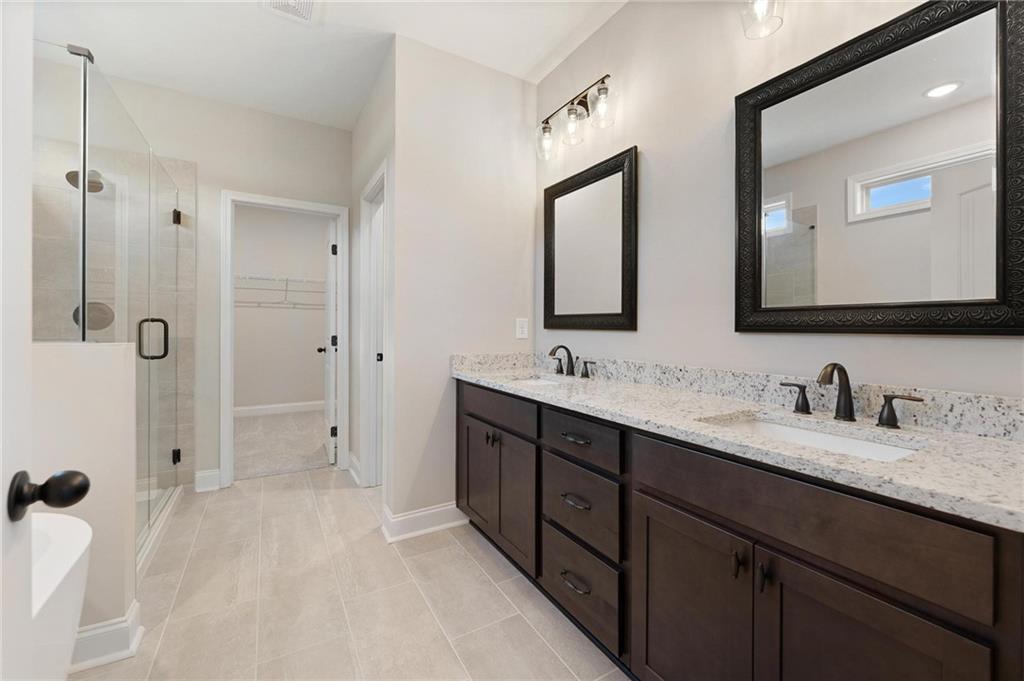 280 Camden Loop Jefferson, GA 30549 - Photo 19 of 43 a bathroom with a double vanity sink mirror double and shower