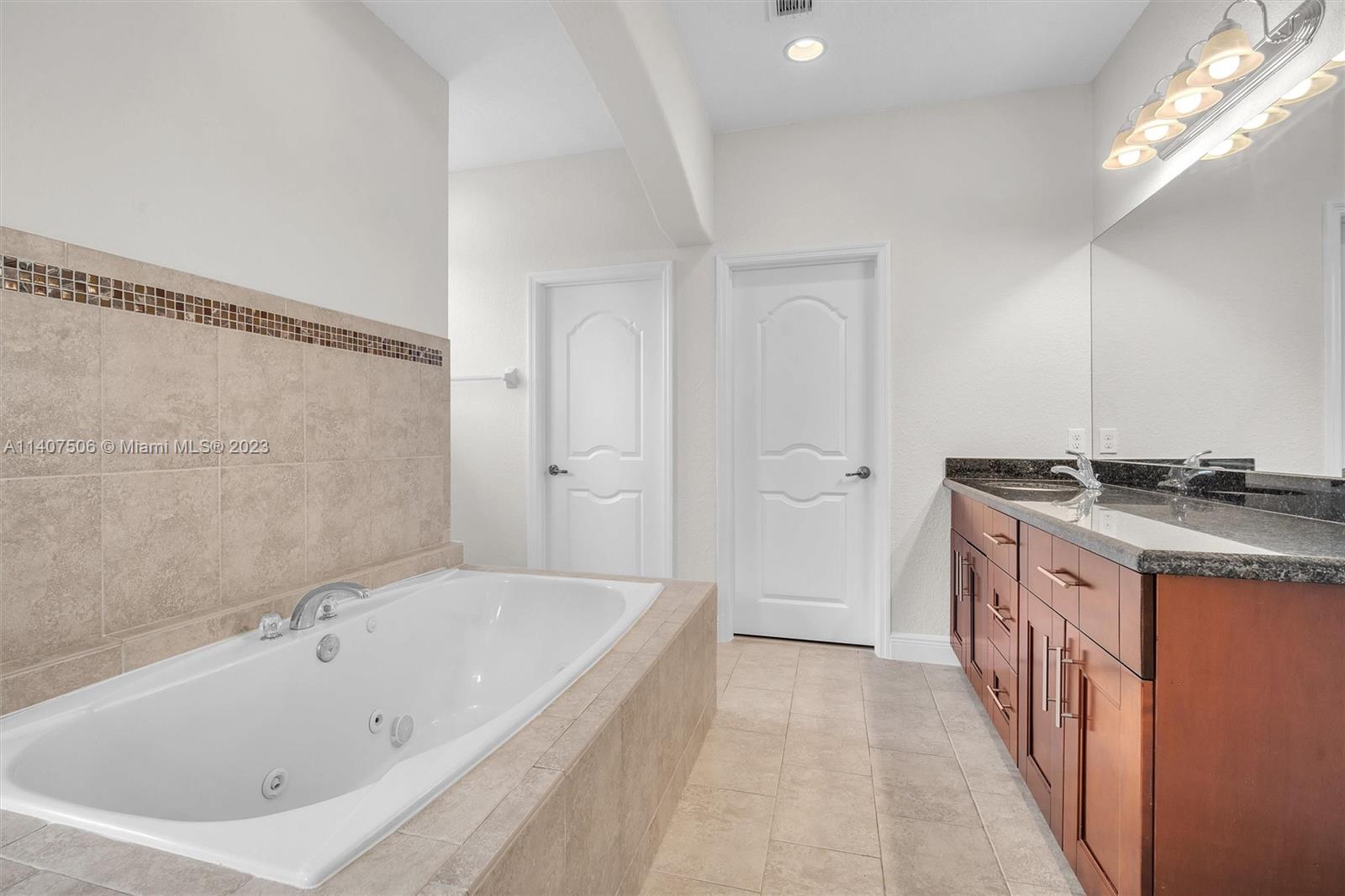 Tamiami Miami, FL 33184 - Photo 27 of 46 a spacious bathroom with a granite countertop tub sink and shower