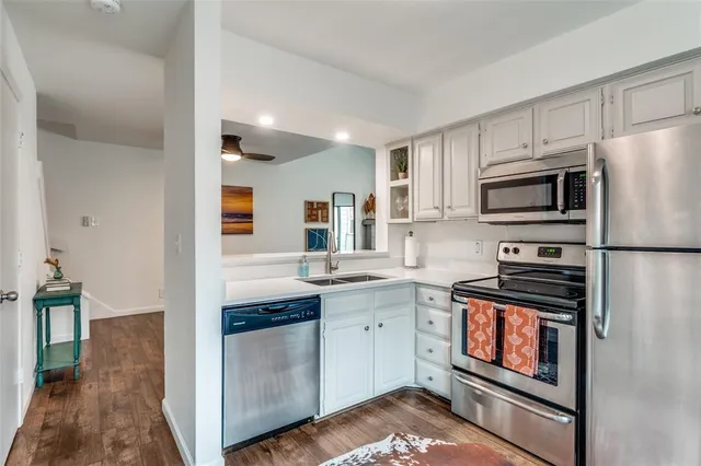 a kitchen with stainless steel appliances granite countertop a stove top oven a sink and dishwasher