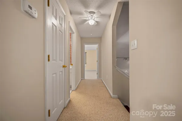 a view of a hallway with a chandelier fan