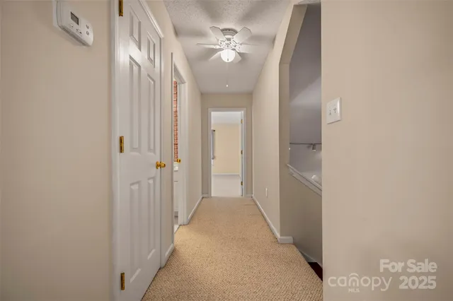 a view of a hallway with a chandelier fan