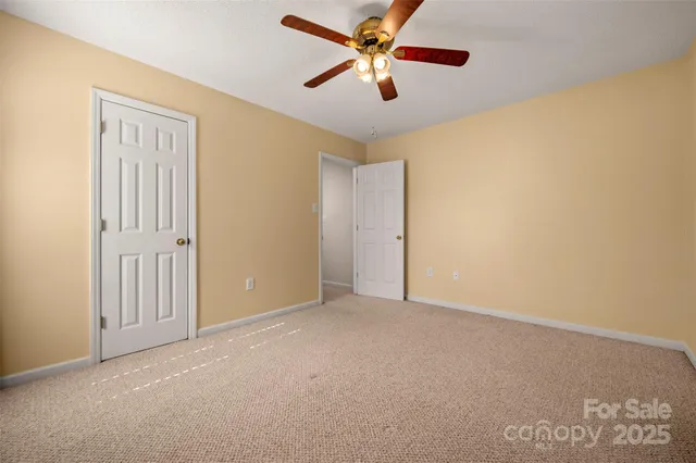 an empty room with chandelier fan