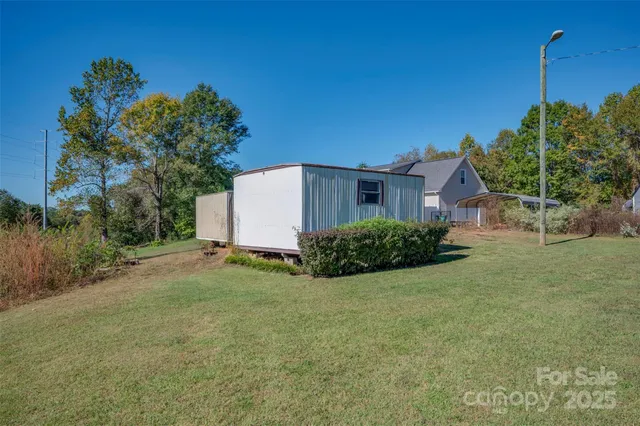 a view of a house with backyard and trees