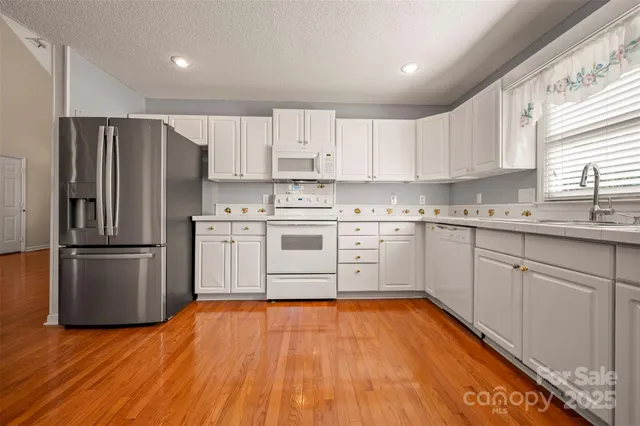 a kitchen with a white cabinets stainless steel appliances and a window