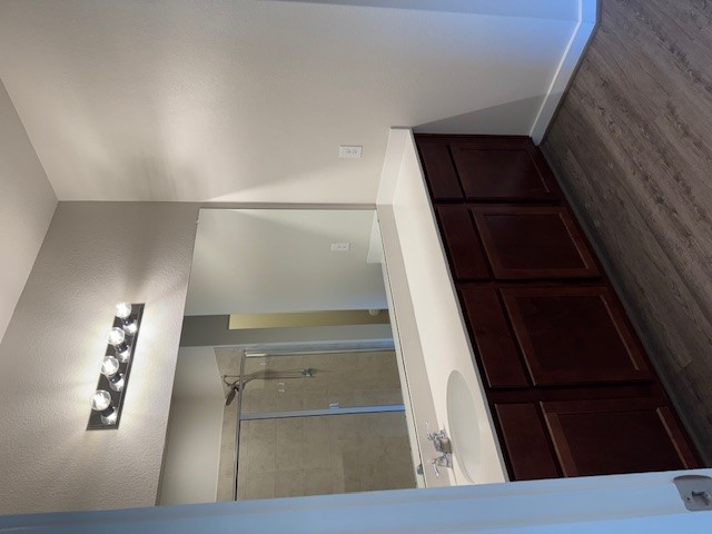 1204 Morning View Road Georgetown, TX 78628 - Photo 9 of 26 Bathroom featuring a stall shower, vanity, and dark wood-type flooring
