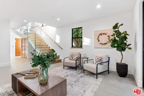 a living room with furniture potted plant and a lamp
