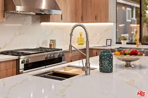 a kitchen with stainless steel appliances granite countertop a refrigerator and a sink