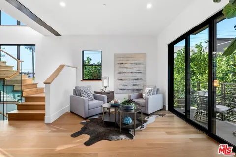 a balcony with wooden floor and outdoor seating