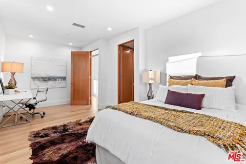 a bedroom with a bed and wooden floor