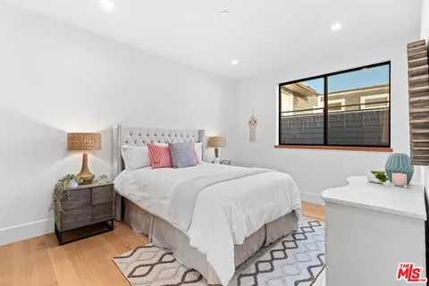 a spacious bedroom with a bed and wooden floor