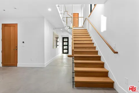 a view of entryway and hall with wooden floor