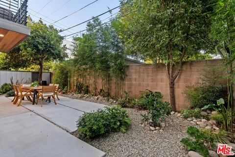 a view of a backyard with a bench and some trees