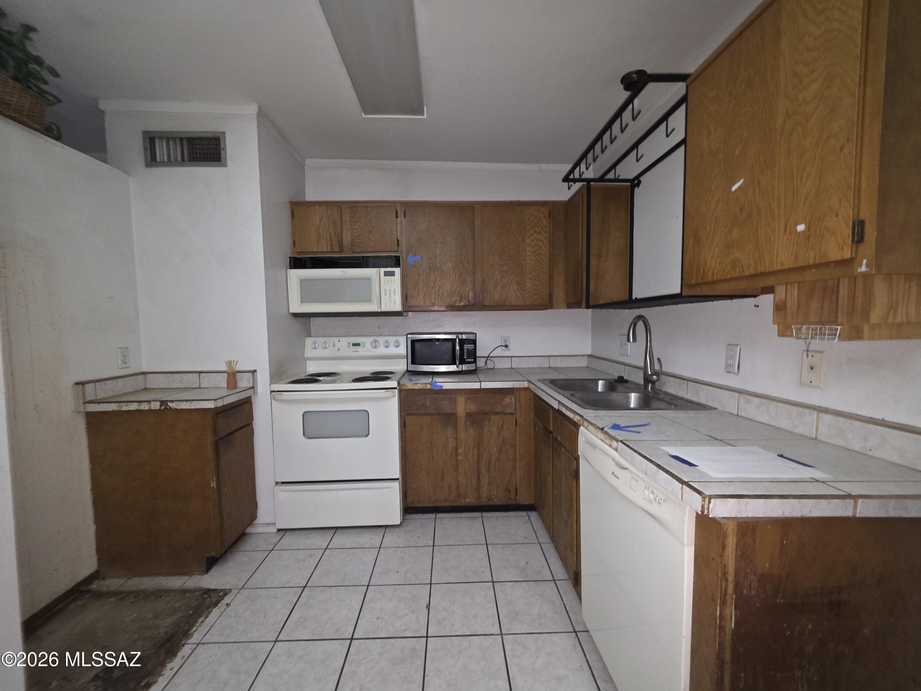 211 West Roger Road, Unit 24 Tucson, AZ 85705 - Photo 8 of 24 a kitchen with a sink stove and cabinets