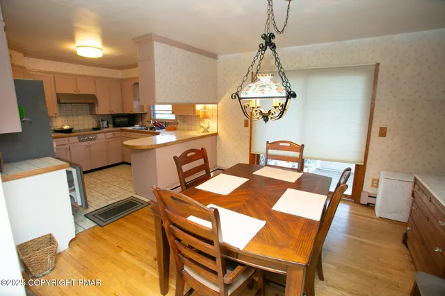 a dining room with a table chairs and a kitchen view