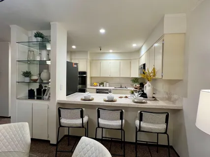 a kitchen with a dining table chairs refrigerator and cabinets