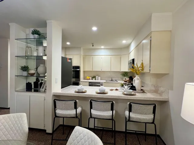 a kitchen with a dining table chairs refrigerator and cabinets
