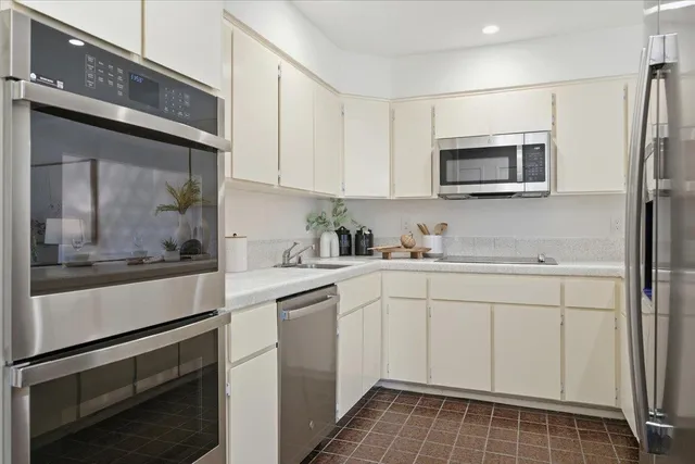 a kitchen with stainless steel appliances white cabinets and a sink