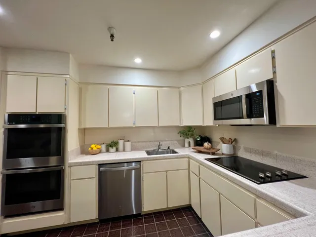 a kitchen with a sink stainless steel appliances and cabinets