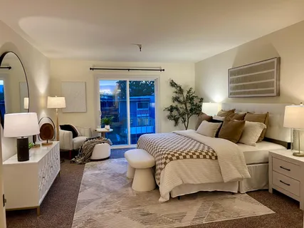 a spacious bedroom with a bed and wooden floor