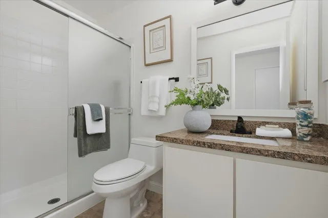 a bathroom with a granite countertop sink mirror and toilet