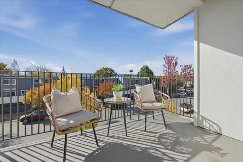 a balcony with wooden floor and outdoor seating