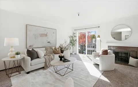 a living room with furniture fireplace and a large window