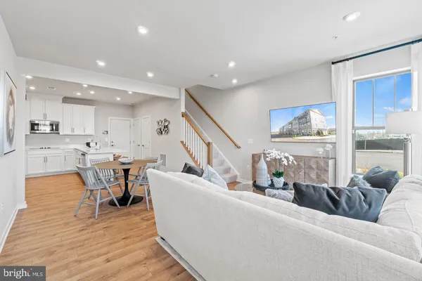 a living room with furniture wooden floor and a large window
