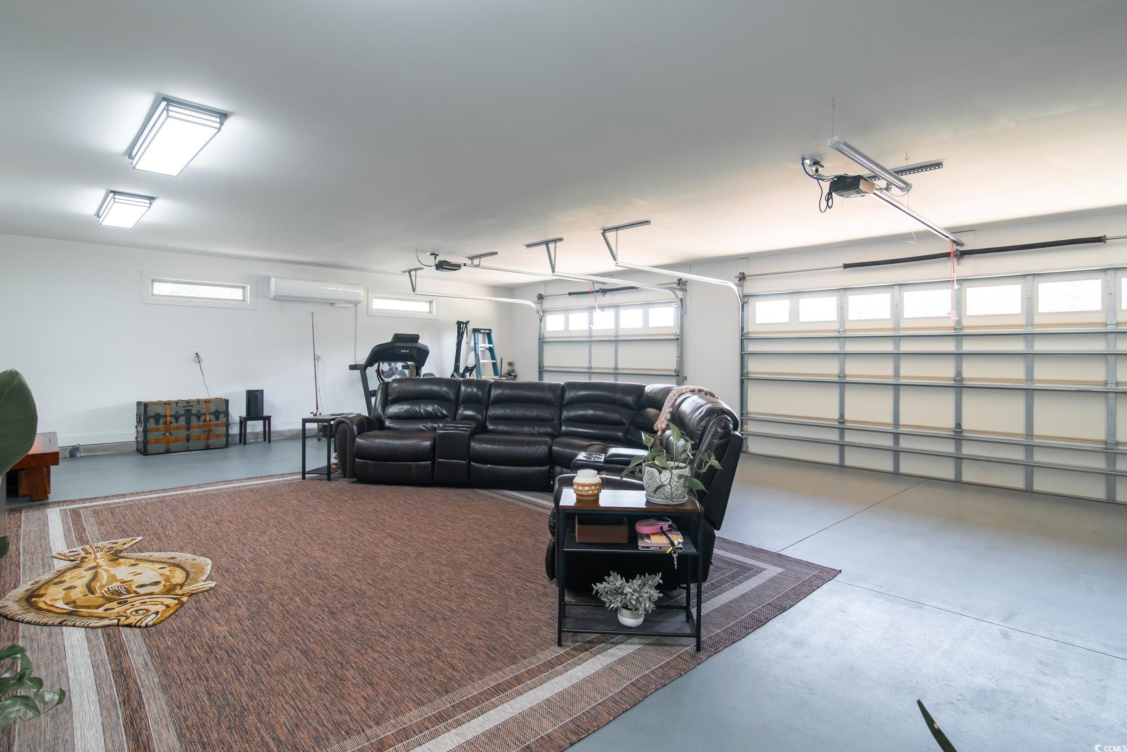 193 Field Loop Road Georgetown, SC 29440 - Photo 26 of 40 Garage with an AC wall unit and a garage door open