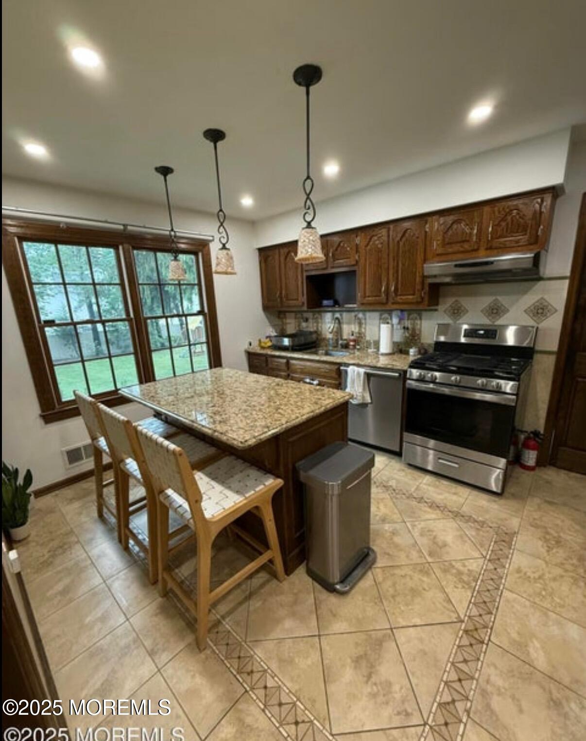 530 Wall Street Eatontown, NJ 07724 - Photo 2 of 13 a kitchen with stainless steel appliances granite countertop a stove top oven a sink a dining table and chairs
