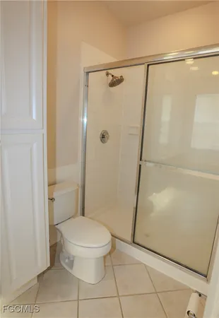 a white toilet sitting next to a shower