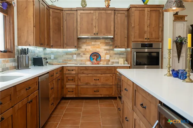 a kitchen with stainless steel appliances a stove sink and cabinets