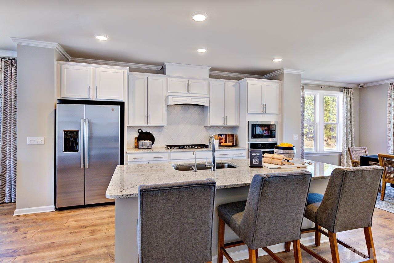 7016 Bent Pine Place, Unit 34 Raleigh, NC 27613 - Photo 8 of 24 a kitchen with refrigerator a stove a sink and chairs