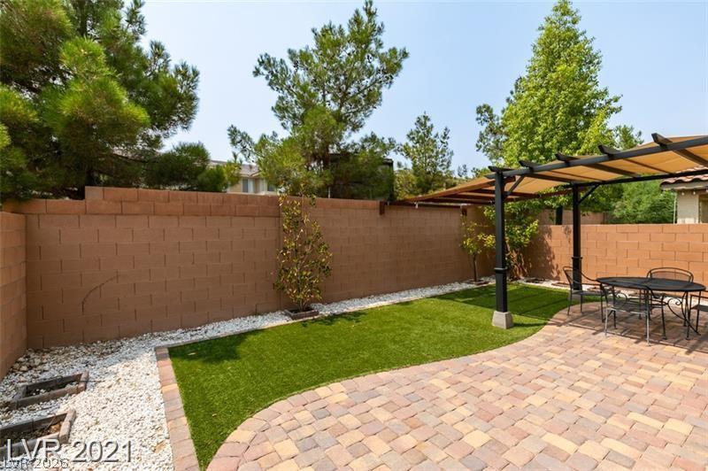 5475 Ordesa Valley Road Las Vegas, NV 89148 - Photo 6 of 35 A private outdoor space features a decorative brick wall and a charming patio with a covered pergola.