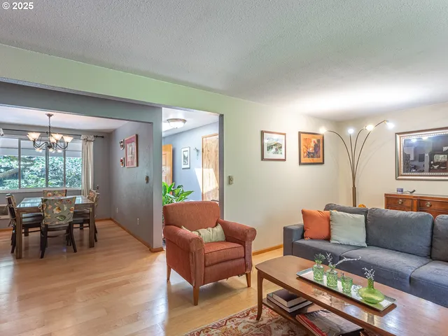 a living room with furniture kitchen view and a large window