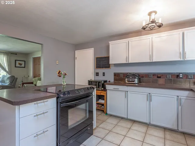 a kitchen with granite countertop a sink stove and cabinets